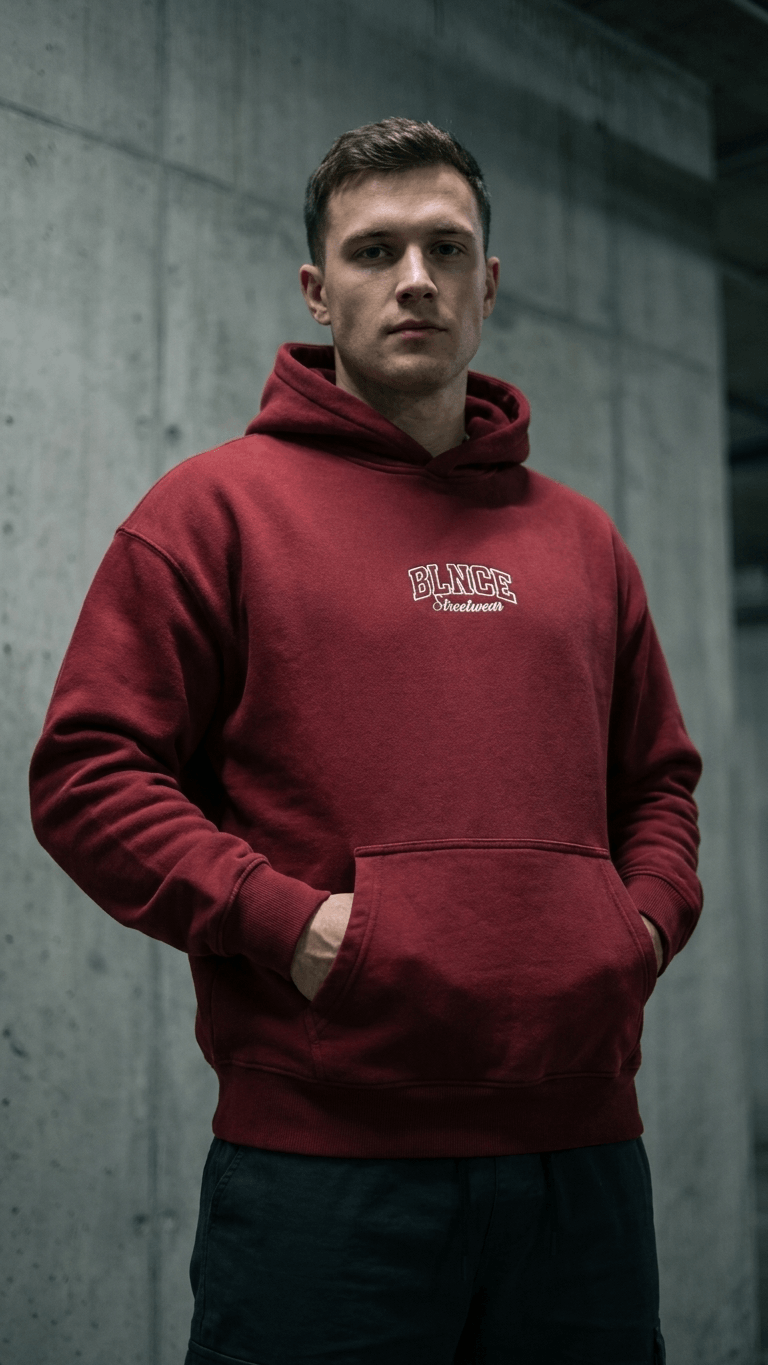 Model wearing a red street coded lux hoodie with pockets, showcasing urban fashion style.